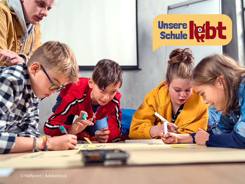 Schülerinnen und Schüler gestalten ein Plakat. 