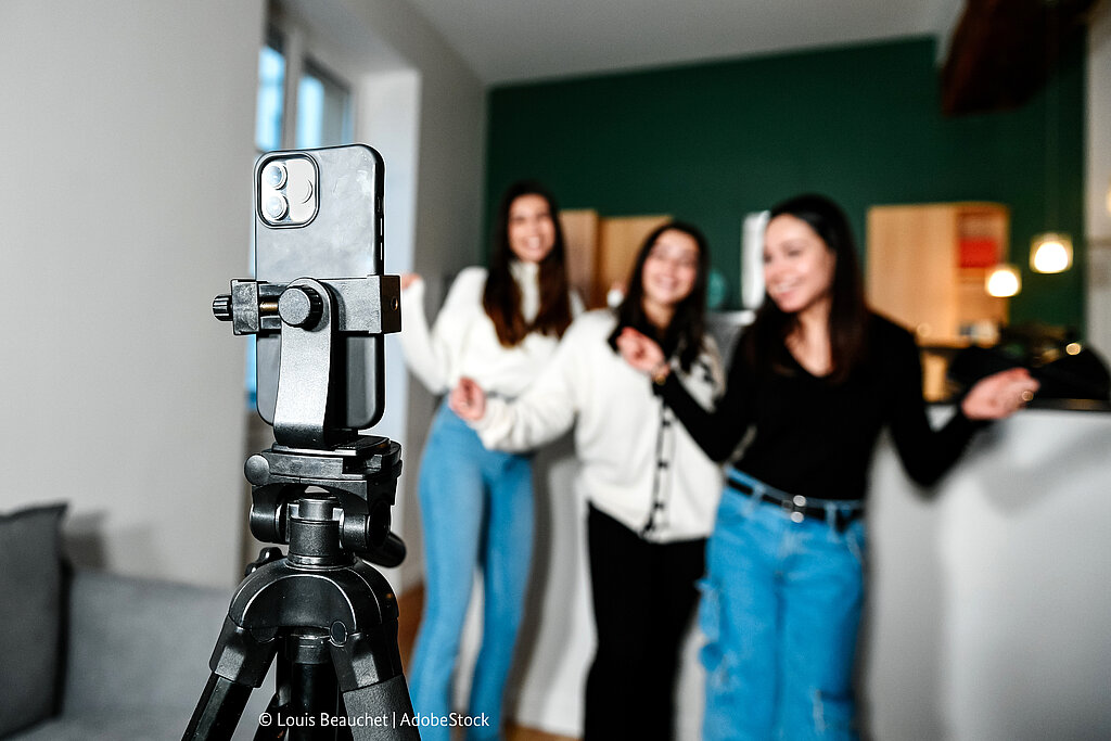 Schülerinnen nehmen Video mit Handy auf